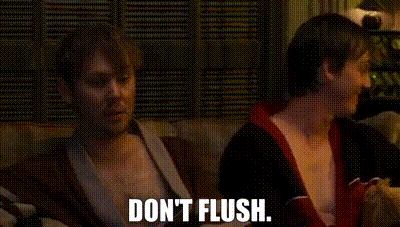 two men are sitting on a couch and one of them is saying `` don t flush '' .
