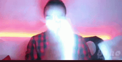 a man in a plaid shirt is holding a light in his hand .