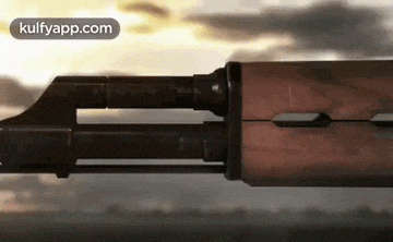 a close up of a rifle with a cloudy sky in the background