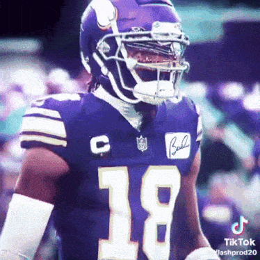 a football player wearing a purple jersey with the number 18