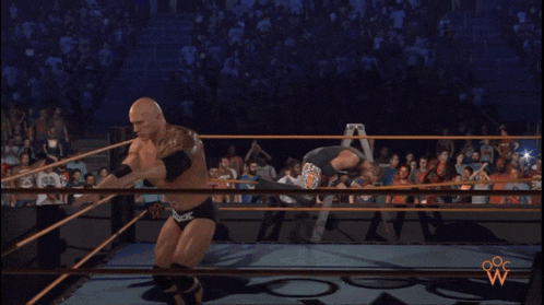 two wrestlers in a ring one of whom is wearing a tank top that says ' harley enforcer '