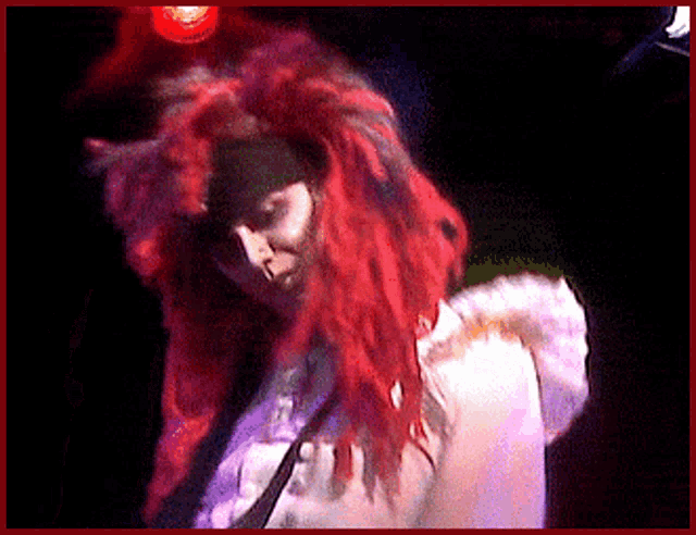 a man with red hair and dreadlocks is wearing a white shirt