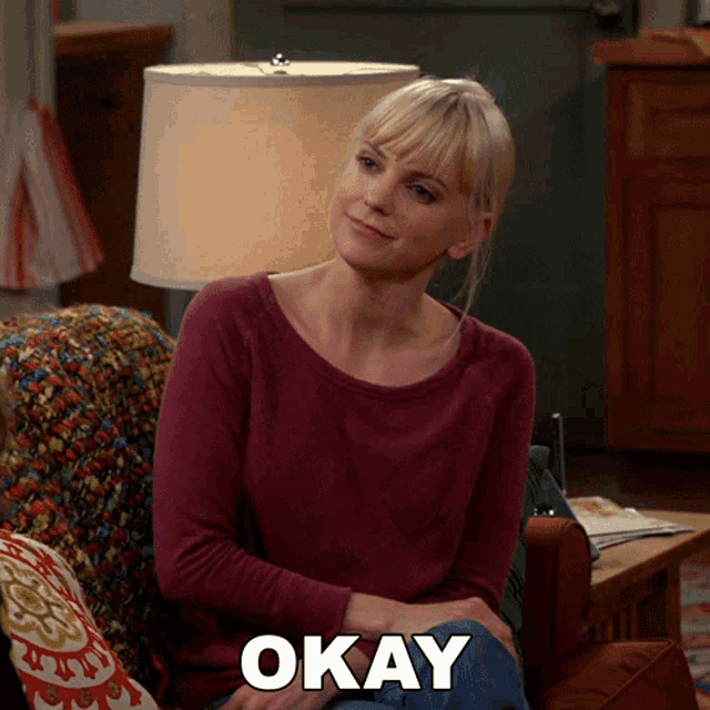 a woman sits on a couch with the word okay written on the bottom