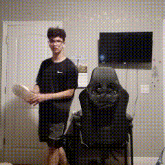 a man is standing next to a chair in a room with a tv .