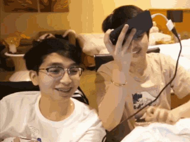 a man wearing glasses is holding a cell phone over his face