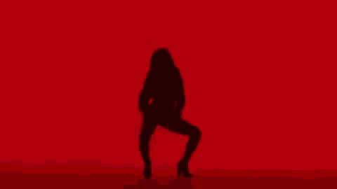 a silhouette of a woman dancing on a red background