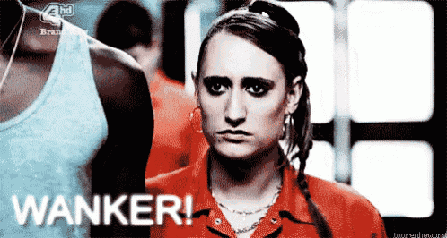 a woman in a red shirt is standing in front of a sign that says wanker !