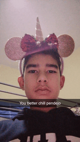 a young man wearing a unicorn headband says " you better chill pendejo " in a snapchat