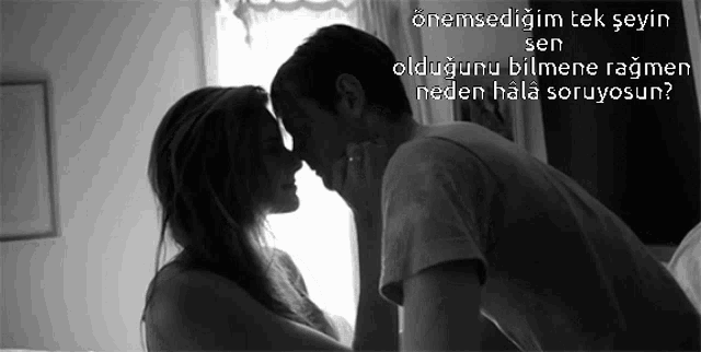 a black and white photo of a man and woman kissing with a foreign language caption