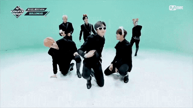a group of people are dancing on a stage with a mnet logo in the corner