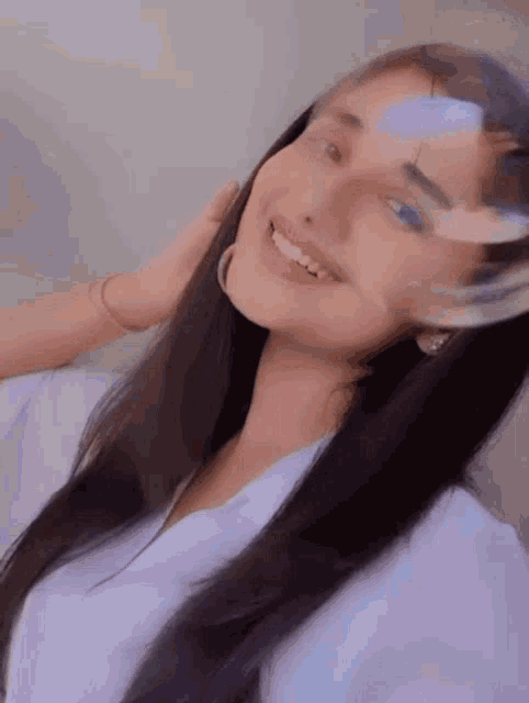 a woman with long black hair is smiling and looking at the camera