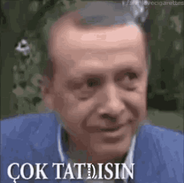 a close up of a man 's face with a cigarette in his mouth and the words `` çok tatlisin '' .