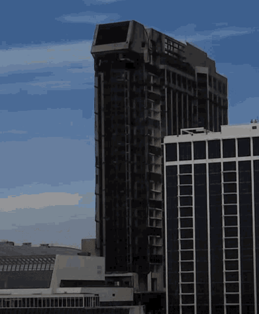 a tall building with a lot of windows and a blue sky behind it