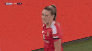 a woman in a red adidas jersey is standing in front of a sign that says ticala