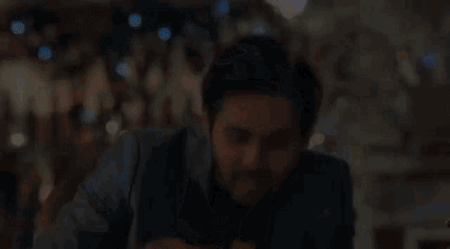 a man in a suit and tie is sitting at a table eating a sandwich .