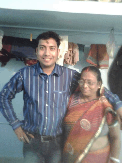 a man in a blue striped shirt stands next to a woman