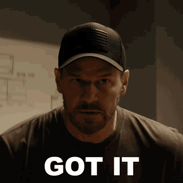 a man wearing a hat and a t-shirt with the word got it on it