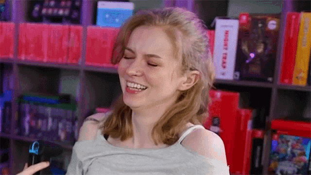 a woman is smiling in front of a bookshelf with a book titled night train on it