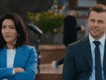 a man and a woman are sitting next to each other with their arms crossed