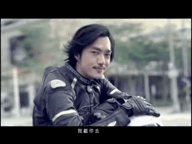 a man wearing a jacket with the letter s on it is sitting on a motorcycle