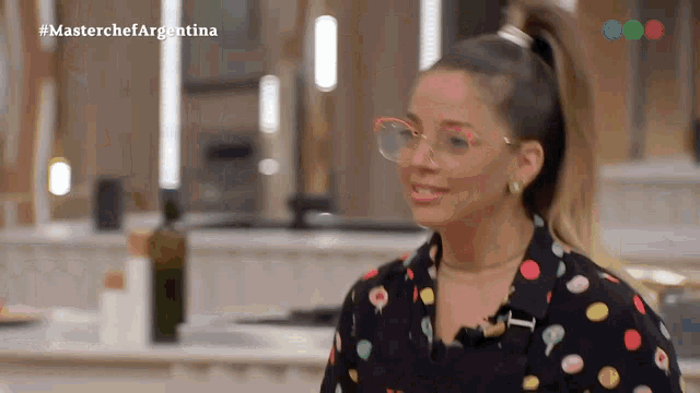 a woman wearing glasses and a colorful polka dot shirt is on a television show called masterchef argentina