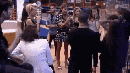 a group of people are standing around a man in a black shirt .