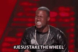 a man in a leather jacket is standing in front of a microphone and says jesus take the wheel .