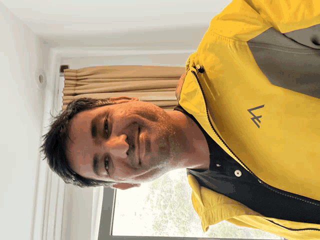 a man wearing a yellow jacket with a l on it