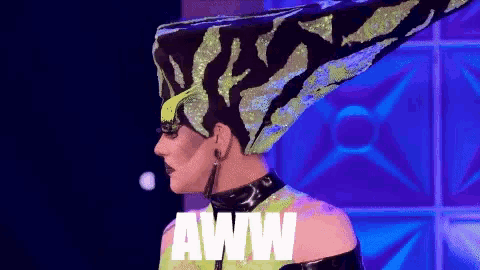 a drag queen wearing a zebra print hat with the word aww written on it .