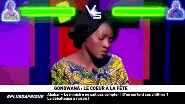 a woman is sitting in front of a screen that says gondwana le coeur a la fête
