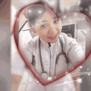 a woman with a stethoscope around her neck takes a selfie in a heart shaped mirror