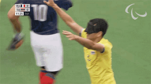 a soccer player wearing a blindfold celebrates a goal against france