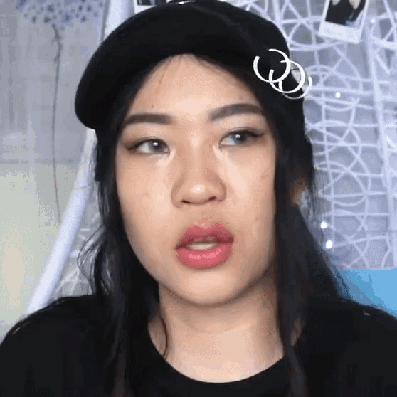 a close up of a woman wearing a hat and earrings