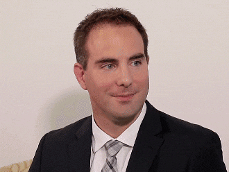 a man in a suit and tie is sitting on a couch