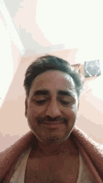 a man with his eyes closed is wearing a red sweater