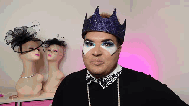 a man wearing a crown and pearls is standing in front of a row of mannequins