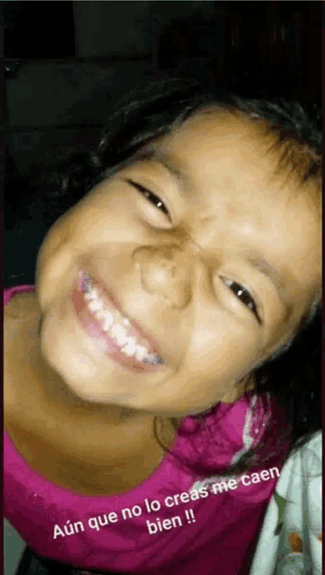 a little girl with braces on her teeth is smiling with a caption that says aún que no lo creas me caen bien