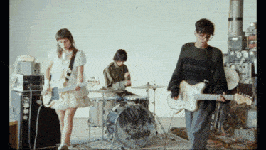 a group of people playing instruments including a man playing a guitar