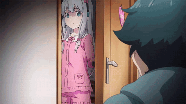 a girl in a pink pajama stands in a doorway next to a boy
