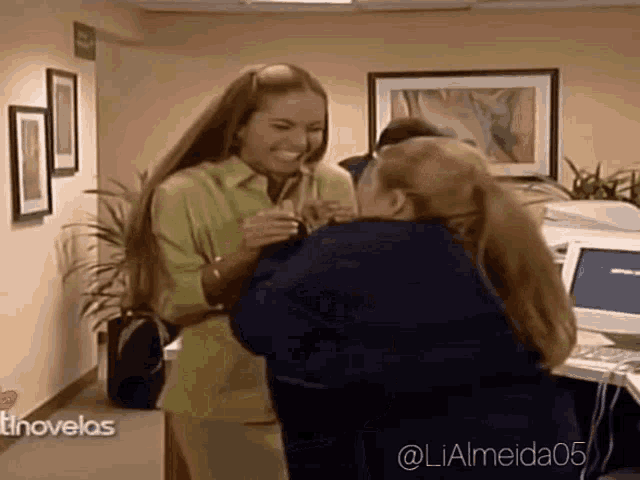 two women are hugging in a hallway with the hashtag lialmeida05 on the bottom
