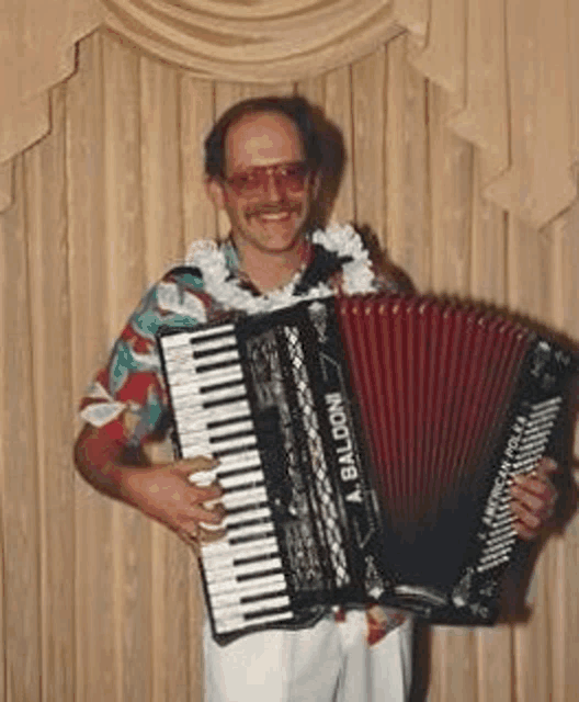 a man in a hawaiian shirt is playing an accordion .