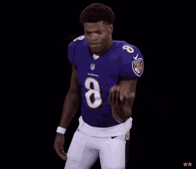 a football player in a purple uniform with the number 8 on it