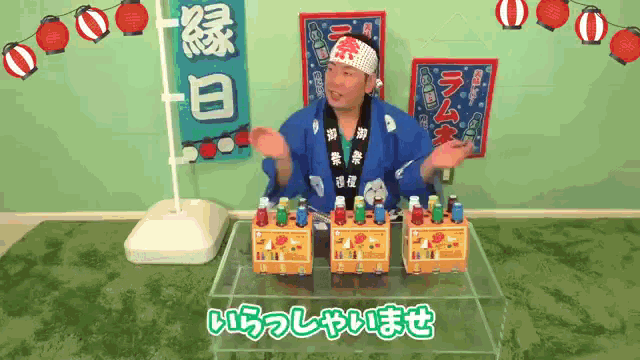 a man wearing a headband with chinese writing on it is standing in front of a table full of bottles