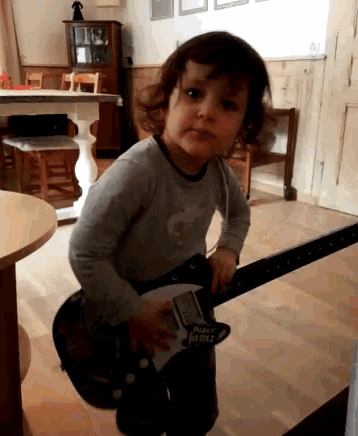 a young boy is playing a guitar that says rock n roll on it