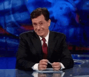 a man in a suit and tie sits at a desk