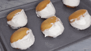 a bunch of cakes with white frosting on them