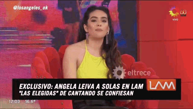 a woman in a yellow top is sitting in a red chair on a television screen
