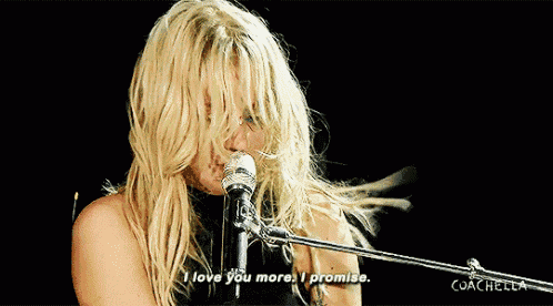 a blonde woman singing into a microphone with the words " i love you more i promise "