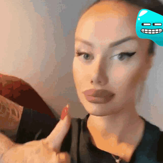 a woman with red nails and a blue face on her forehead