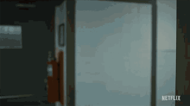 a woman with red hair is peeking out from behind a door that says netflix